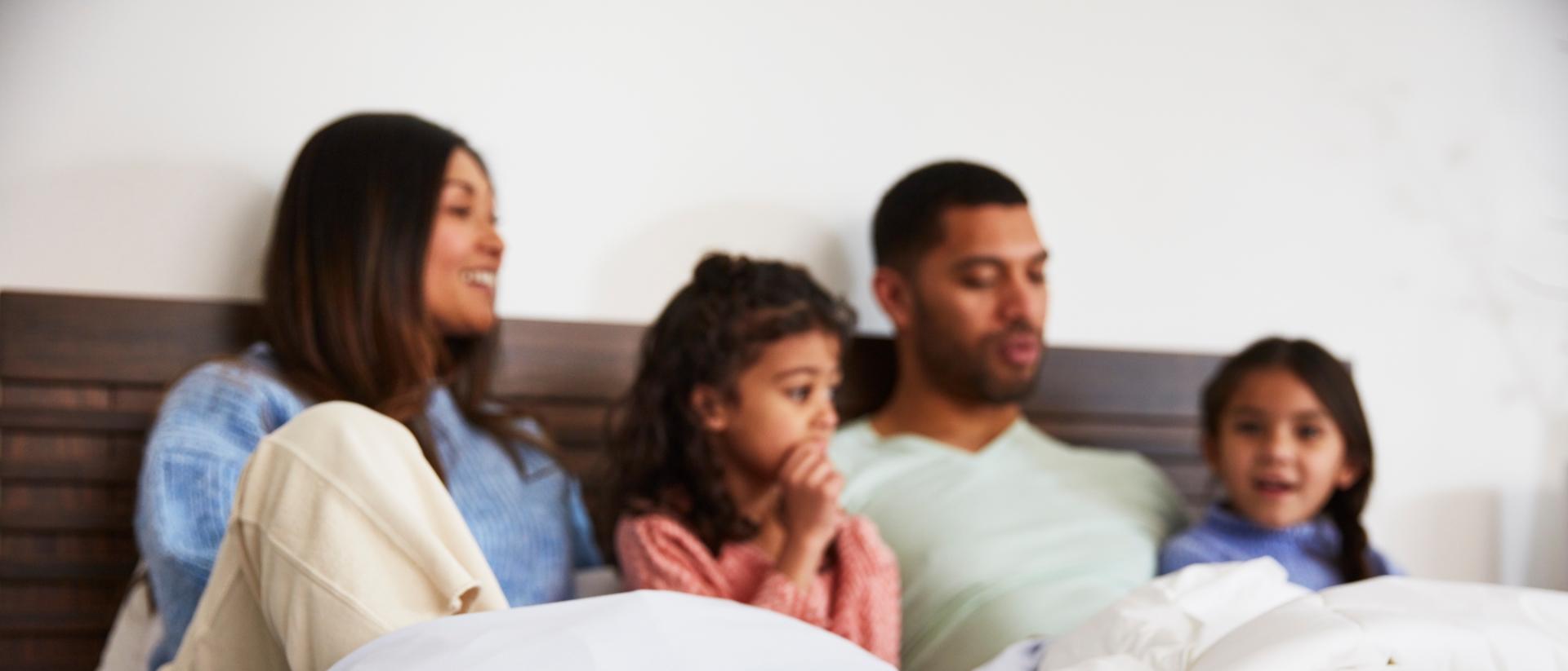 family sitting in bed